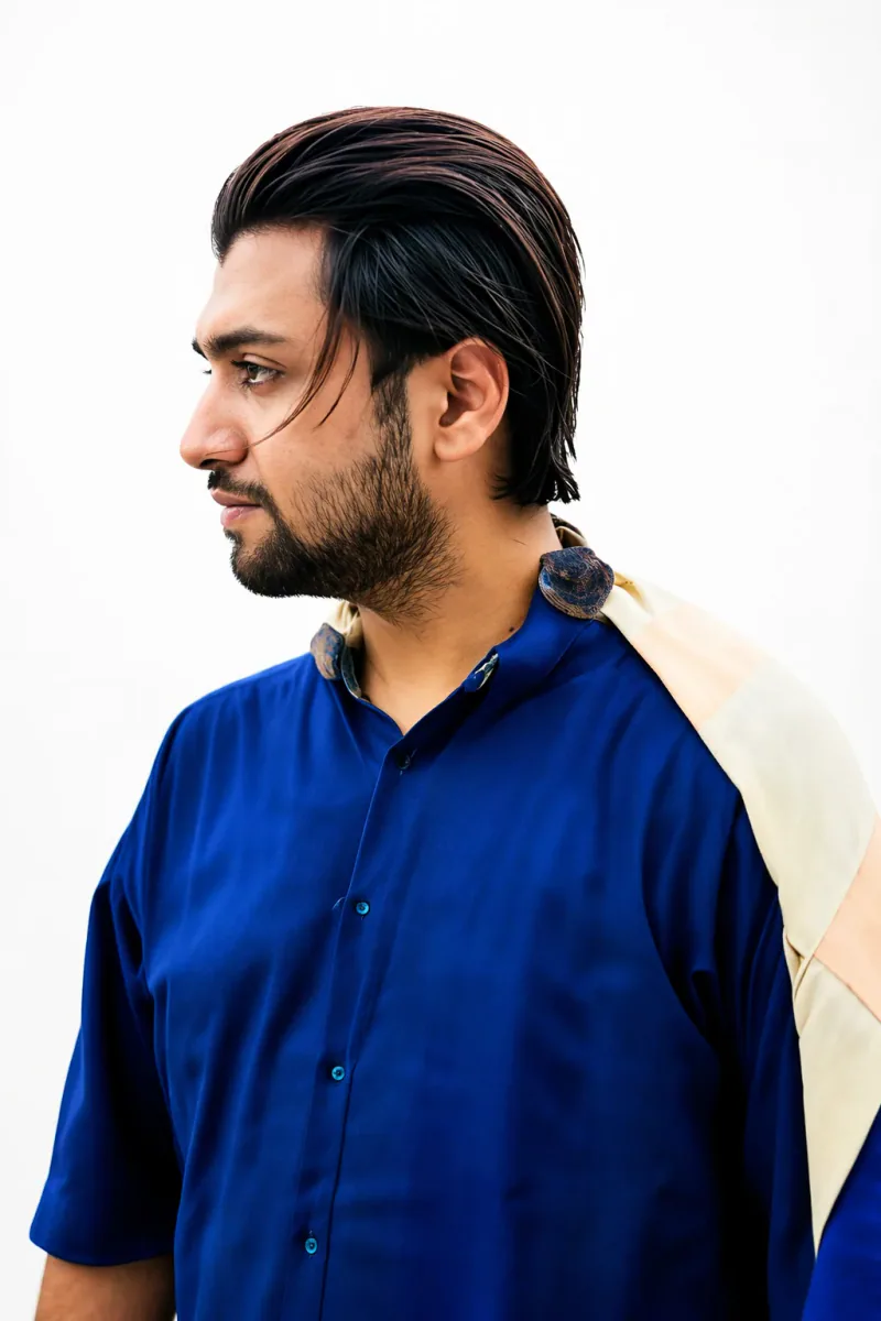 Mir Ahadul Islam in profile, wearing a blue kurta against a white wall
